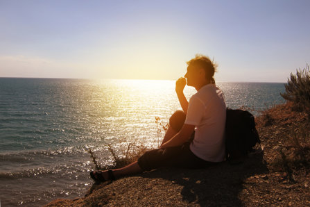 Un hombre sentado al sol en el mar 